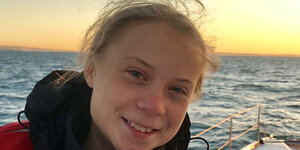 Greta Thunberg und die Sonne geht über dem Meer auf