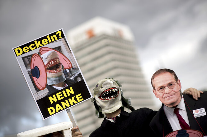 Ein Demonstrant trägt eine Maske mit dem Gesicht von Berlins Bürgermeister Michael Müller