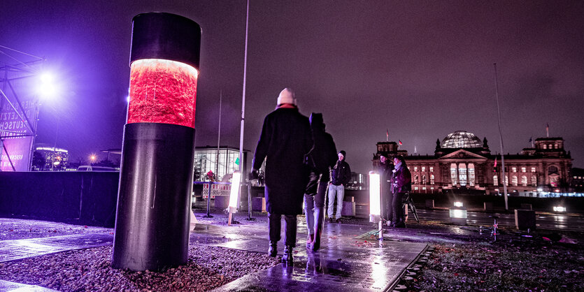 beleuchtete Säule, im Hintergrund Reichstag bei Nacht