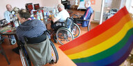 Ältere Menschen im Pflegeheim und eine Regenboden-Fahne