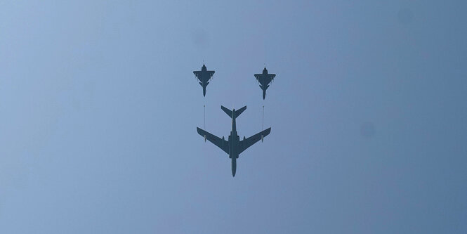 Militaerflugzeuge fliegen in Formation