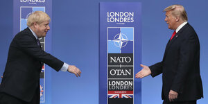 Boris Johnson und Donald Trump laufen aufeinander zu, die Hand zum Handschlag ausgestreckt.