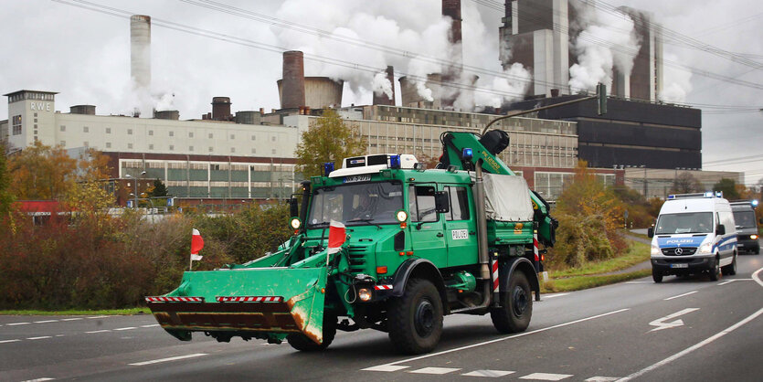 Ein grünes Fahrzeug vor Fabrikgebäuden