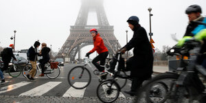 Radfahrer vor dem Eifelturm im Nebel