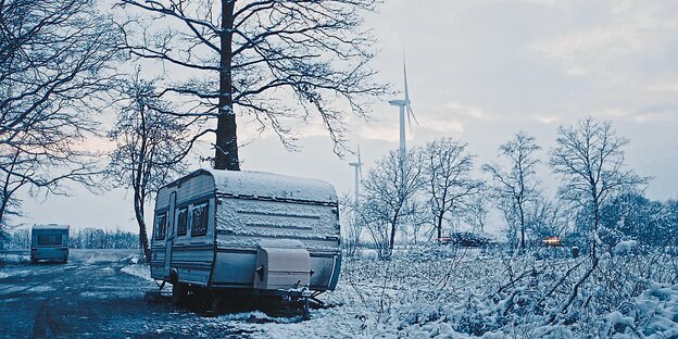 Ein Wohnwagen steht in einer trostlosen Winterlandschaft.