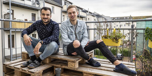 Zwei junge Männer sitzen auf einem Balkon