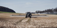 Ein Traktor fährt über ein Feld und bringt Glyphosat aus