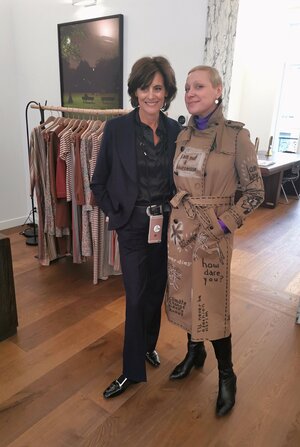 Zwei Frauen stehen nebeneinander, links Inès de la Fressange im schwarzen Hosenanzug, rechts Marina Razumovskaya im von Inès bemalten Trenchcoat Zwei Frauen stehen nebeneinander, links Inès de la Fressange im schwarzen Hosenanzug, rechts Marina Razumovskaya im von Inès bemalten Trenchcoat