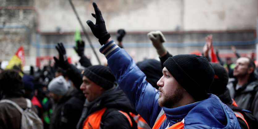 Männer in roten Warnwesten beim Protestzug in Paris