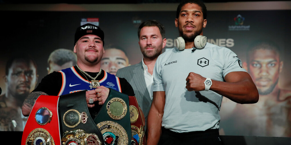 Zwei Boxer prosieren mit den WM-Gürteln vor der Kamera