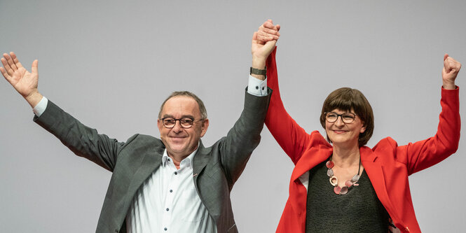 Mann und Frau reißen Arme hoch