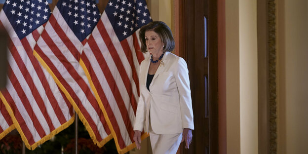 Nancy Pelosi läuft an USA-Flaggen vorbei