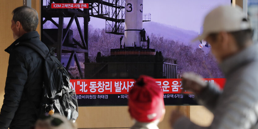 Reisenden am Bahnhof von Seoul in Südkorea. Im Fernsehen wird über den Raketentest im Nachbarstaat Nordkorea berichtet.