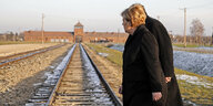 Angela Merkel schaut auf die Bahngleisde, die in das Vernichtungslager Auschwitz führen