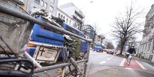 Blick auf eine Einmündung mit rotem Fahrradweg, links ein Geländern, an dem ein weiß gestrichenes Fahrrad lehnt mit dem Hinweis auf eine tödlich verunglückte Radlerin