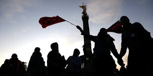 Silhouette von Extinction-Rebellion-Aktivisten undAktivistinnen vor der Siegessäule in Berlin