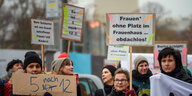 Teilnehmerinnen einer Demonstration für mehr finanzielle Mittel in Frauenhäusern und Vereinen stehen mit Schildern ("Frauen* ohne Platz im Frauenhaus sind obdachlos!") am Internationalen Tag gegen Gewalt an Frauen vor dem Berliner Rathaus