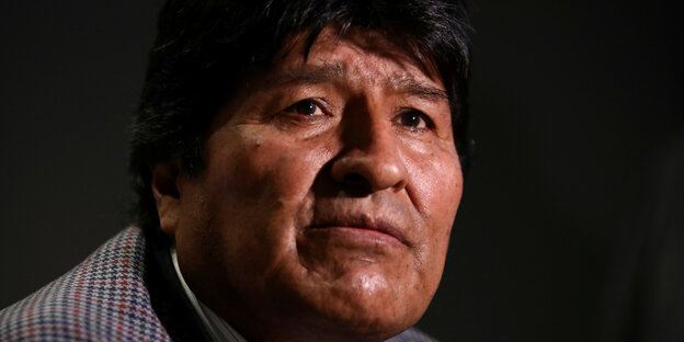 Evo Morales sieht vor einem schwarzen Hintergrund in die Ferne