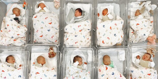 Babys liegen nebeneinander in Betten in einem Krankenhaus