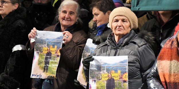 Frauen tragen Plakate mit einem Foto von Peter Handke