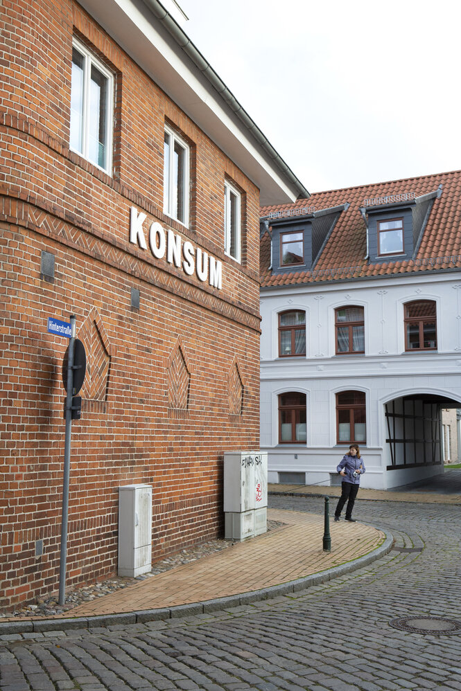 Straßenbild von Grevesmühlen. An einer Fassade steht "Konsum"