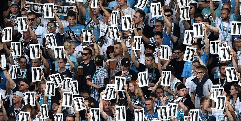 Fans auf der Tribüne mit Zetteln mit der Nr. 11