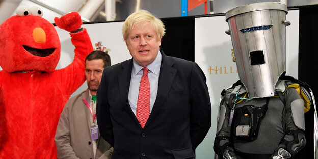 Ein blonder Mann, Boris Johnson, und Verkleidete