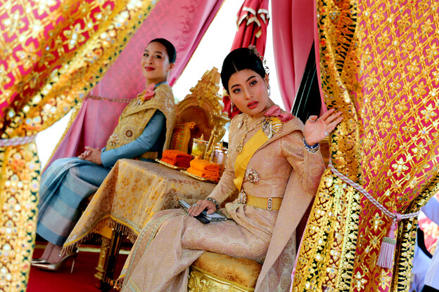 Zwei thailändische Prinzessinnen sitzen auf einem geschmückten Kahn.