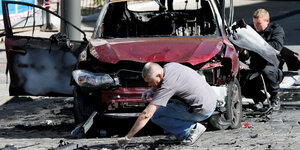 Ermittler untersuchen ein ausgebrandtes Auto nach dem Anschlag auf pavel Scheremet am 2. Juli 2916