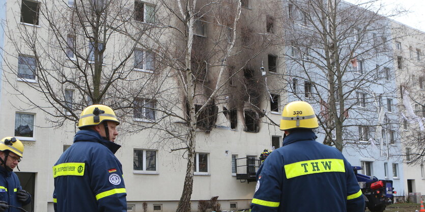 Feuerwehrleute vor rauchendem Haus