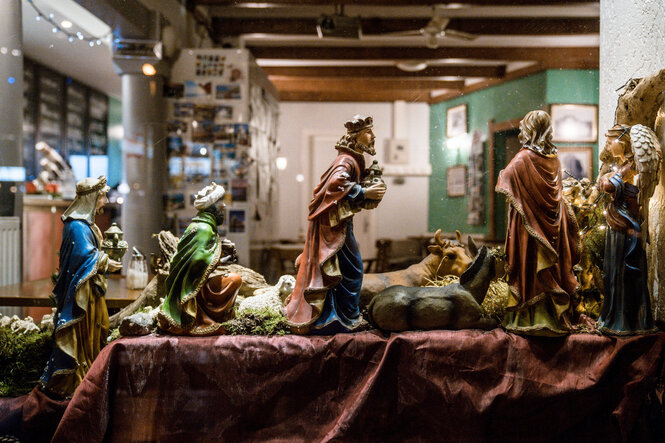 Barocke Krippenfiguren im Fenster einer Kneipe