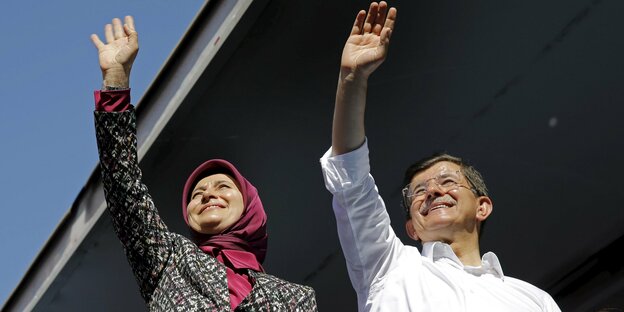 Davutoğlu und seine Frau haben den Arm zum Gruß.