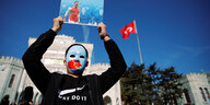 Ein pro-uigurischer Demonstrant hält ein Plakat mit Özil hoch