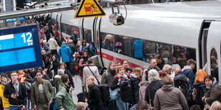 Menschen drängeln auf einem Bahnsteig in einen ICE