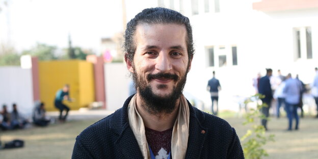 Der Geiger Amin Muqdad steht lächelnd im Freien