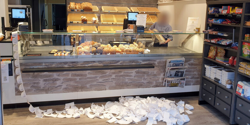 Vor der Verkaufstheke einer Bäckerein lieg ein großer Berg mit Kassenzetteln