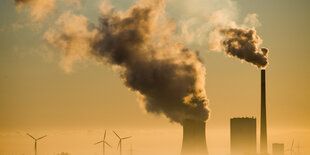 Das Kohlekraftwerk Mehrum und Windräder produzieren Strom im Landkreis Peine (Niedersachsen), während die aufgehende Sonne den Morgennebel in Orangetöne taucht. Vertreter von Bund und Ländern haben nach Informationen der Deutschen Presse-Agentur einen Dur