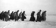 Wehrmachtssoldaten marschieren durch eine Schneelandschaft