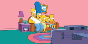 Die Simpsons sitzen versammelt auf dem Sofa vorm Fernseher.