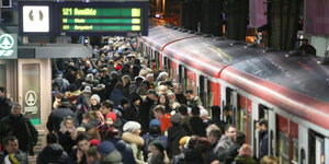 S-Bahnsteig voller Menschen, rechts rote S-Bahn