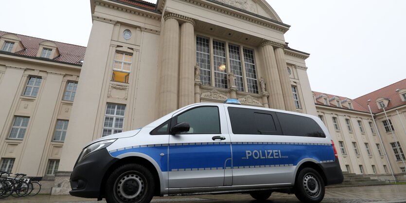 Polizeiauto vor großem Gebäude