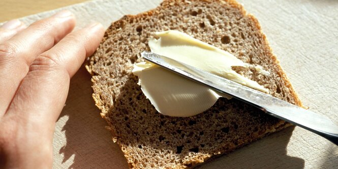 Hand schmiert Butterbrot