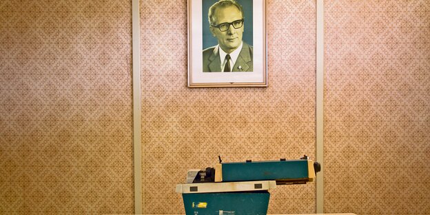 Eine DDR-Schreibmaschine steht unter einem Foto von Erich Honecker.