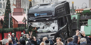 Schaulustige und Reporter stehen vor dem LKW am Weihnachtsmarkt am Breitscheidplatz in Berlin 2016