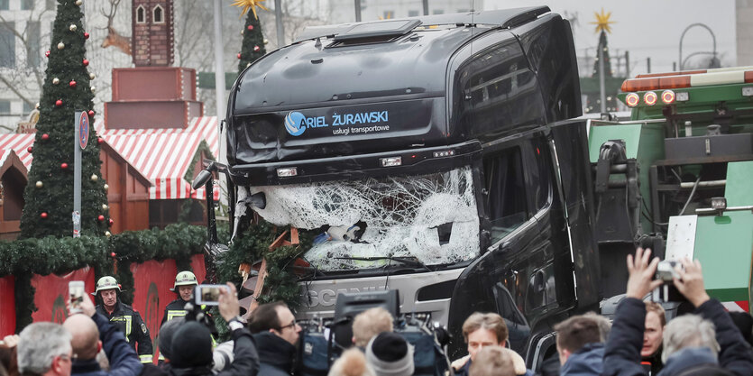 Schaulustige und Reporter stehen vor dem LKW am Weihnachtsmarkt am Breitscheidplatz in Berlin 2016