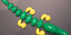 Ein Krokodil aus Plastik, grün mit gelben Füßen