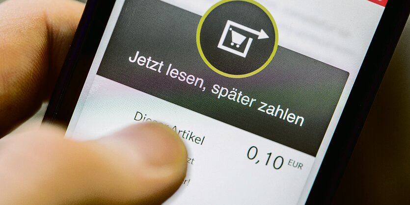 Daumen auf der Bezahl-App eines Smartphones