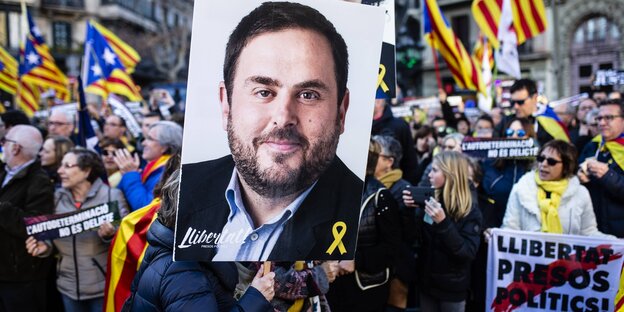 Unabhängigkeitsbefürworter tragen bei einer Demo ein großes Plakat mit einem Foto von Oriol Junqueras