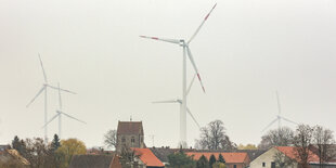 Windräder hinter einem Dorf