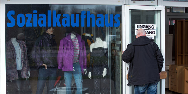 Ein Mann öffnet die Tür zum Sozialkaufhaus der Diakonie in Rostock.